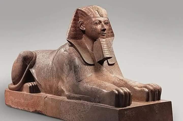 Colossal granite statue of Hatshepsut portrayed as a muscular male king, wearing a false beard and kilt, emphasizing her royal transformation.