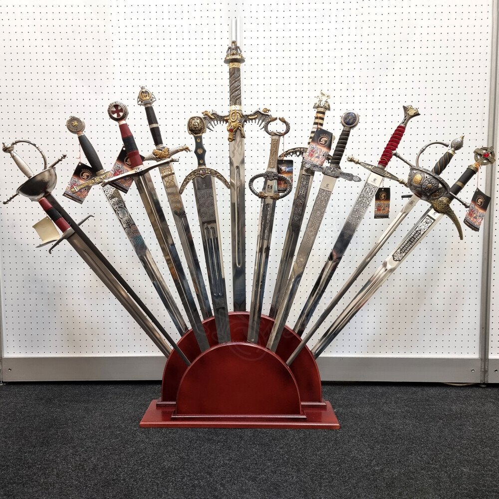 Collection of Schiavona basket-hilted sword replicas displayed on a wooden rack for collectors