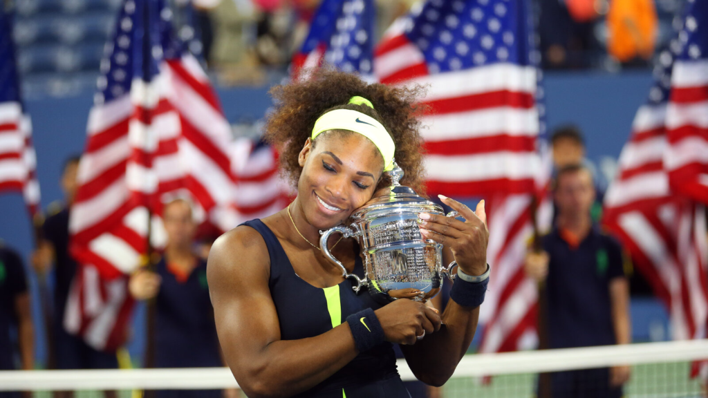 Serena Williams, famous female athlete, holding her tennis trophy after a major Grand Slam victory.